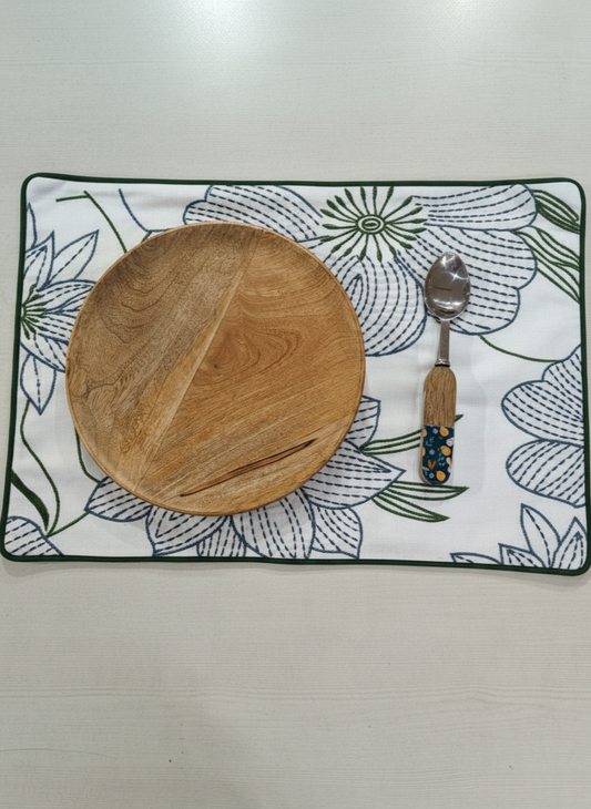 Wooden plate and spoon on a floral placemat