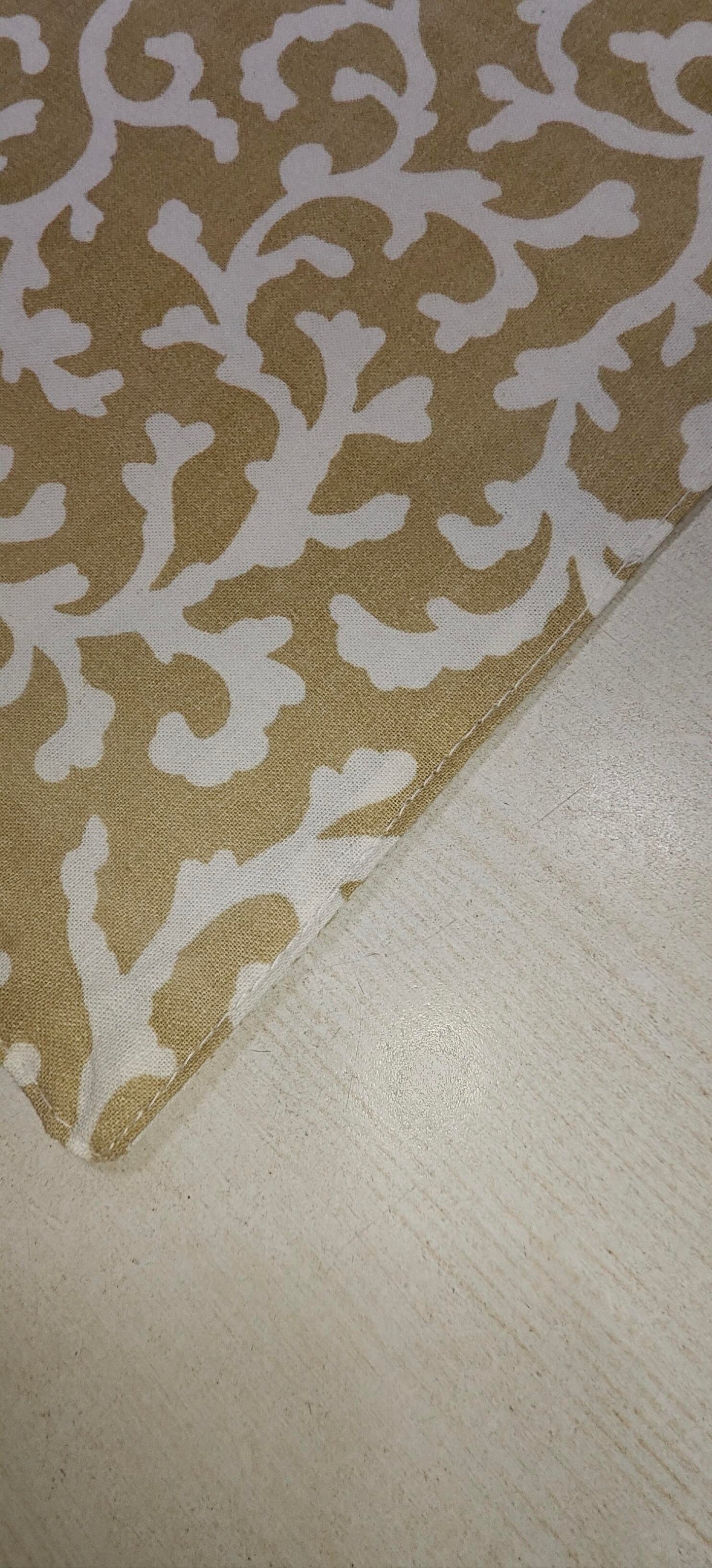 Close-up of golden floral cotton fabric - Viraasa luxury dining