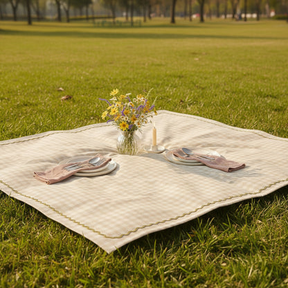 Checkered Table cloth with decorative border, accompanied by potted plants and a folded towel.